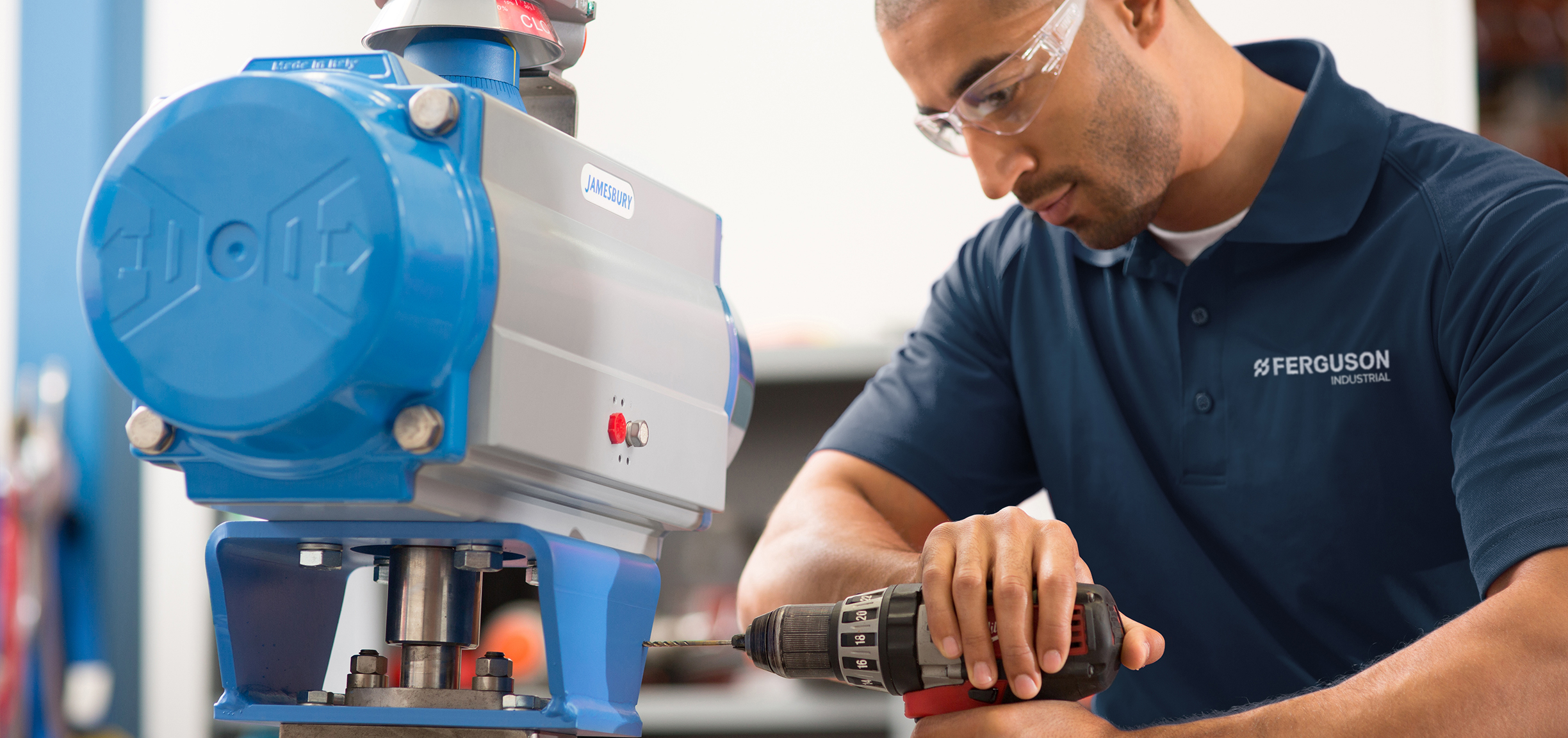 Ferguson associate with industrial expertise working with equipment to customize parts.