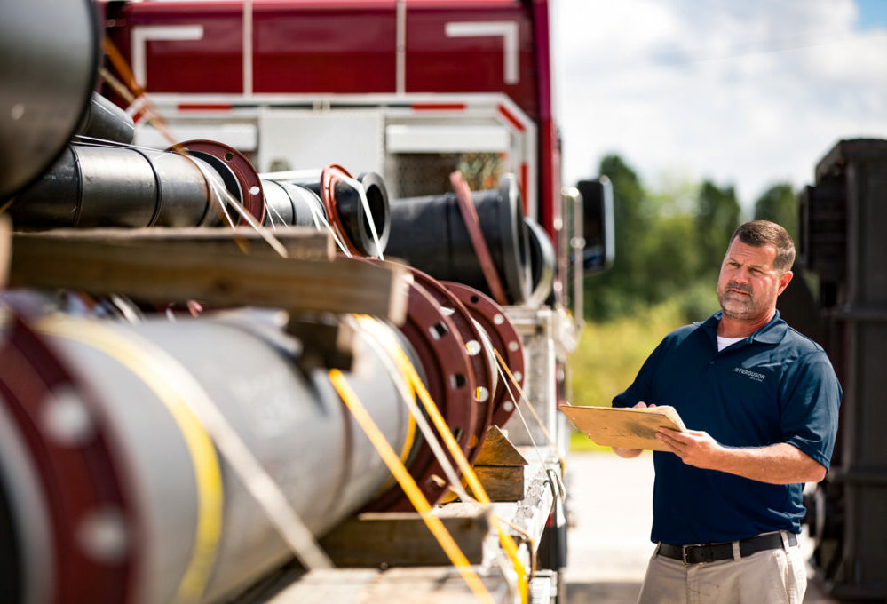 Ferguson Industrial quality assurance associate inspecting an HDPE pipe delivery.