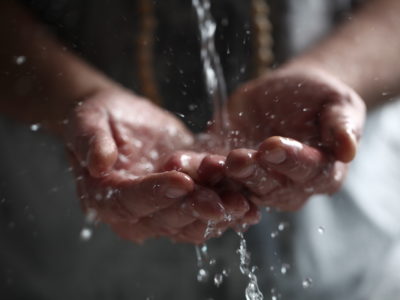 Muslim man washes his hands before prayer ritual cleansing.