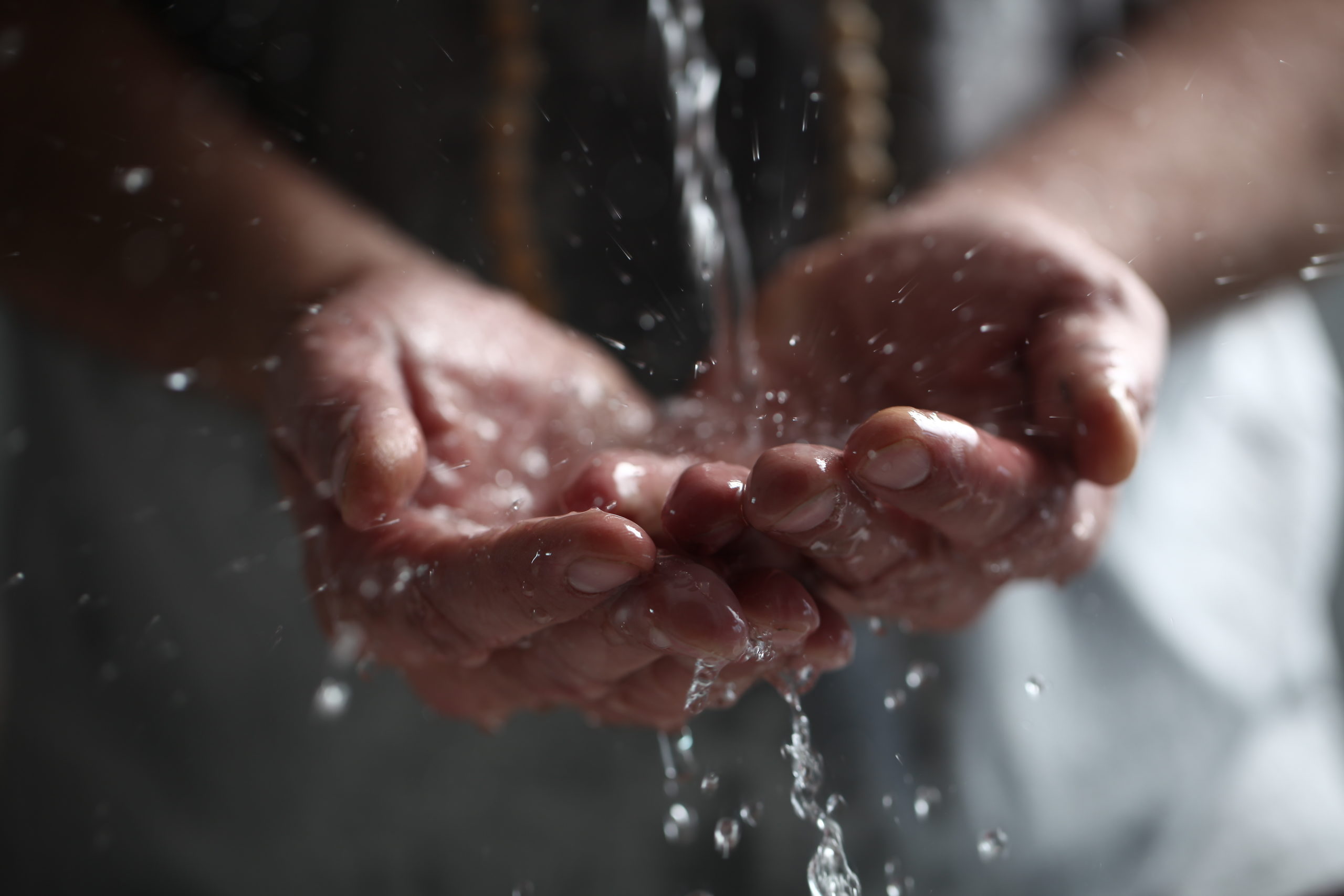 Muslim man washes his hands before prayer ritual cleansing.