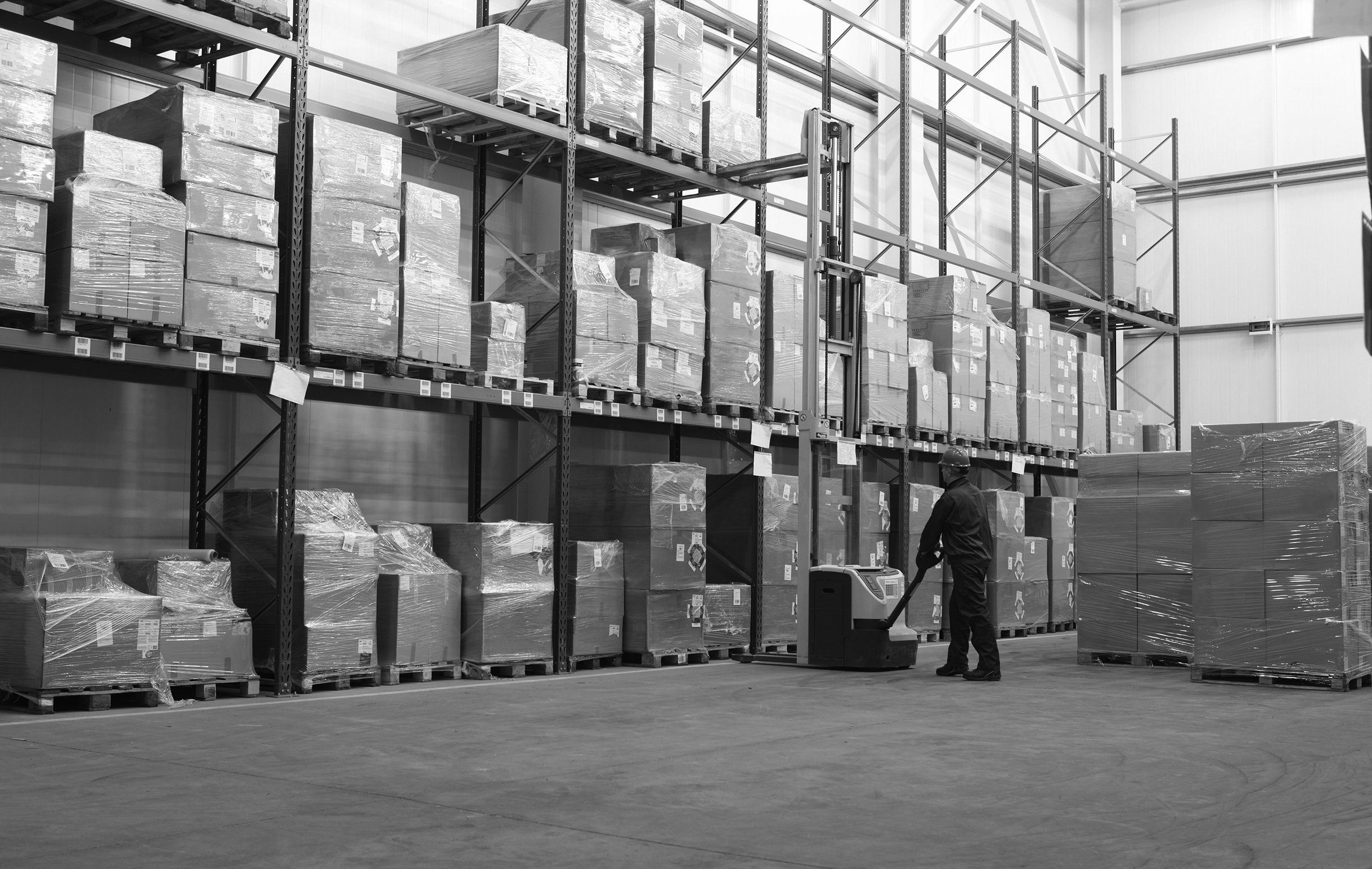 A warehouse with a large amount of safety products and a man working with a safety equipment.