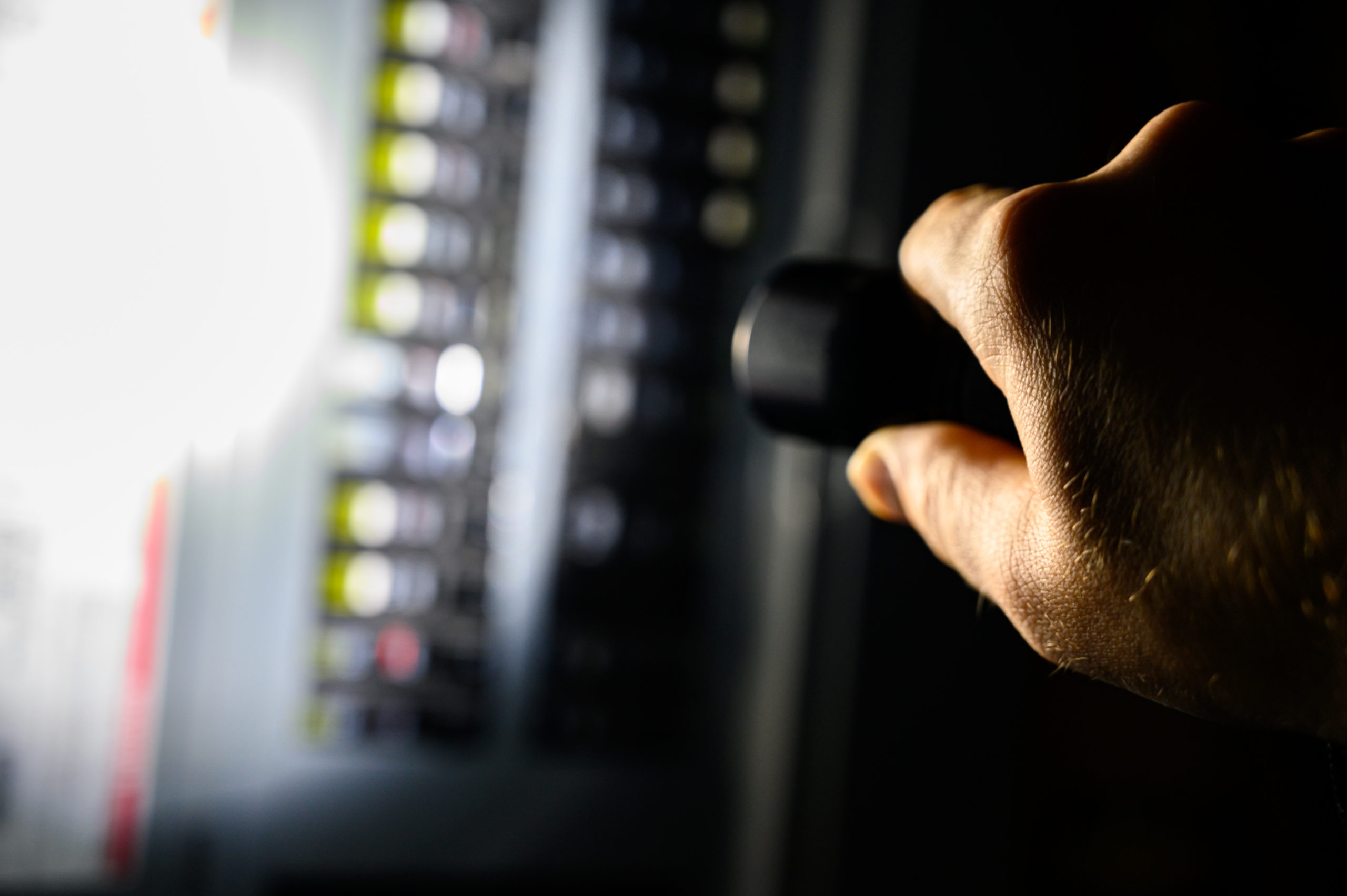 A person holding a flash light during a power outage aimed at a fuse box