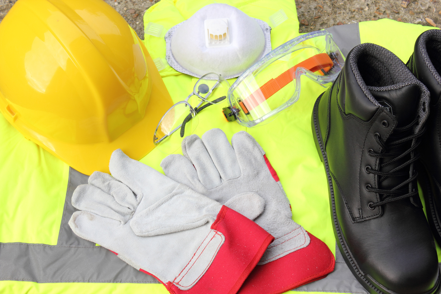 Safety products such as a yellow hard hat, gray gloves, protective eye wear, vest, and black boots.