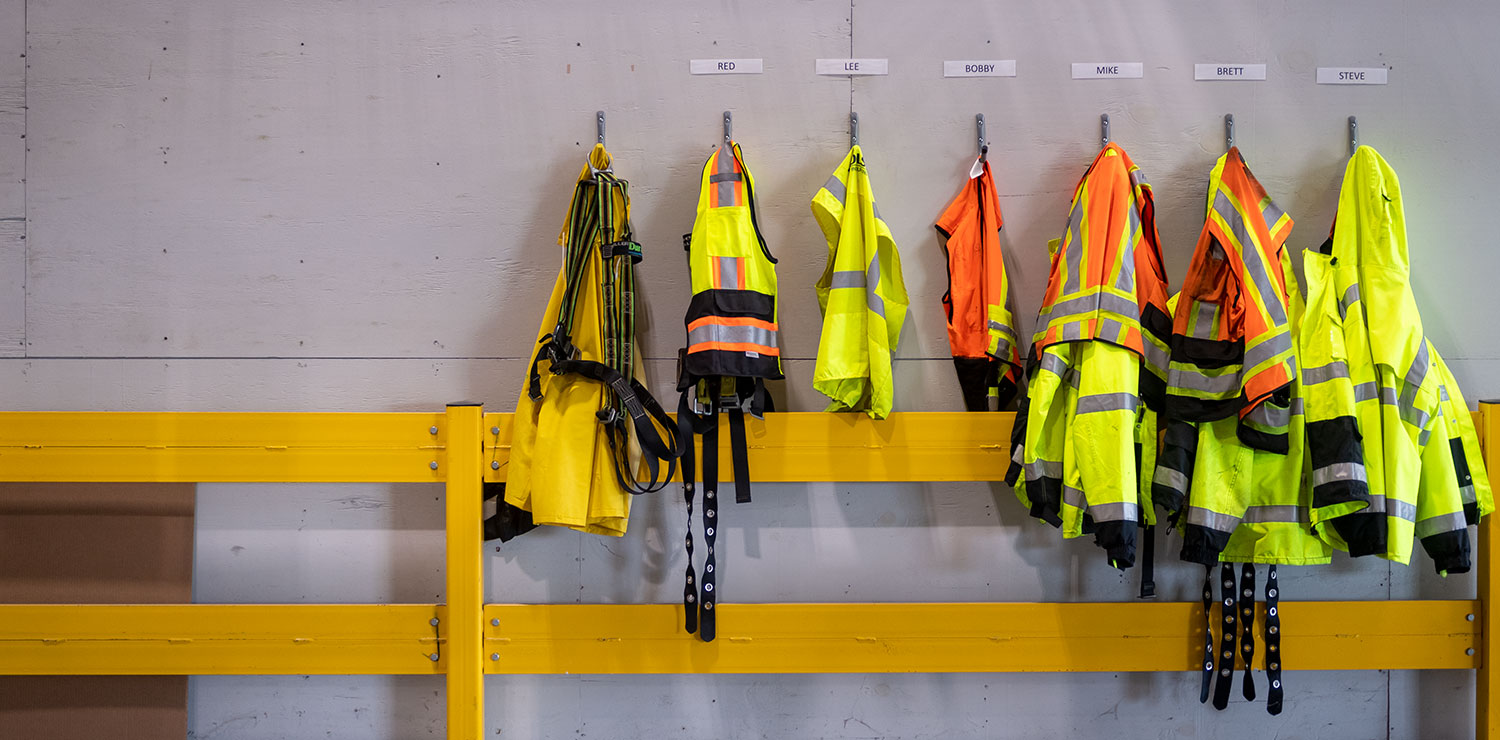 A man holding a safety hard hat to stay within Industrial Workplace Safety standards.