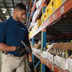 Ferguson Industrial expert inspecting inventory at a client's warehouse as part of our industrial supply software services
