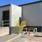 A clean, professional set of access stairs at a warehouse loading zone